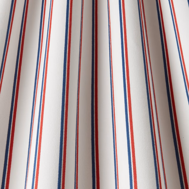 White cotton fabric with narrow navy and red vertical stripes