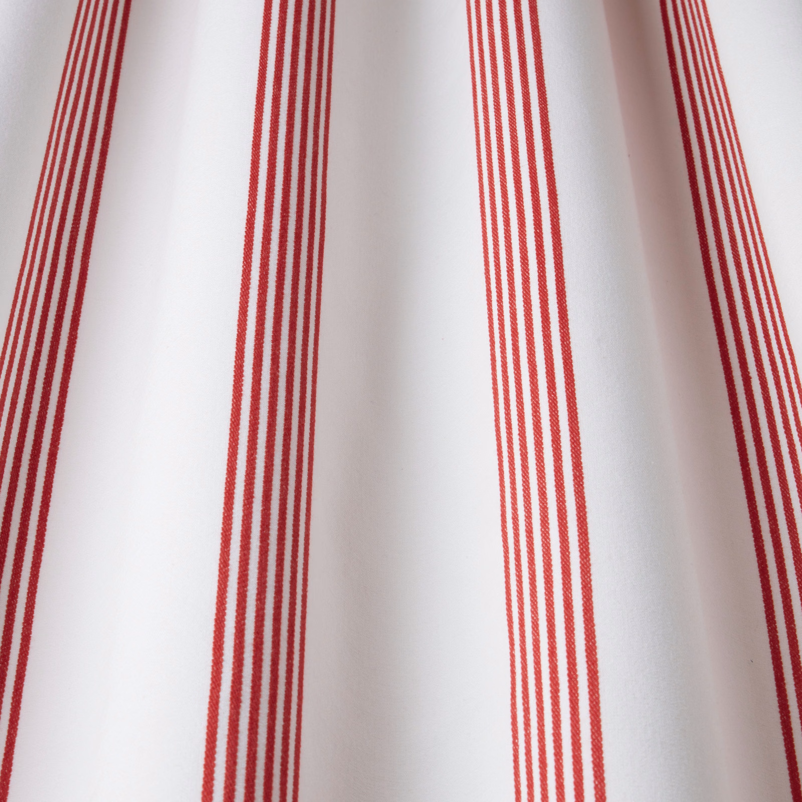 Red vertical pinstripe cotton fabric on a white ground, shown as a swatch