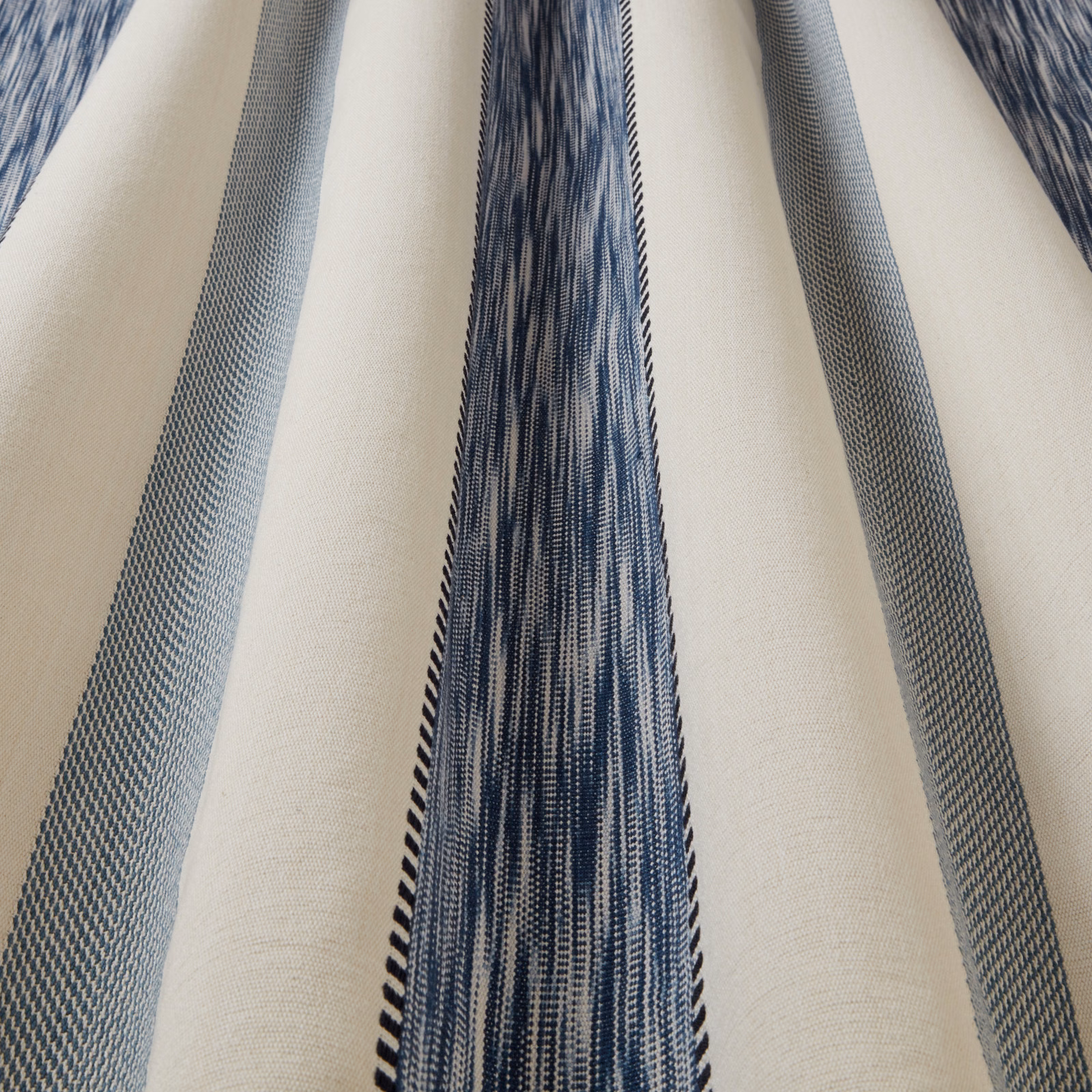 Close-up of a natural cotton fabric with wavy blue vertical stripes