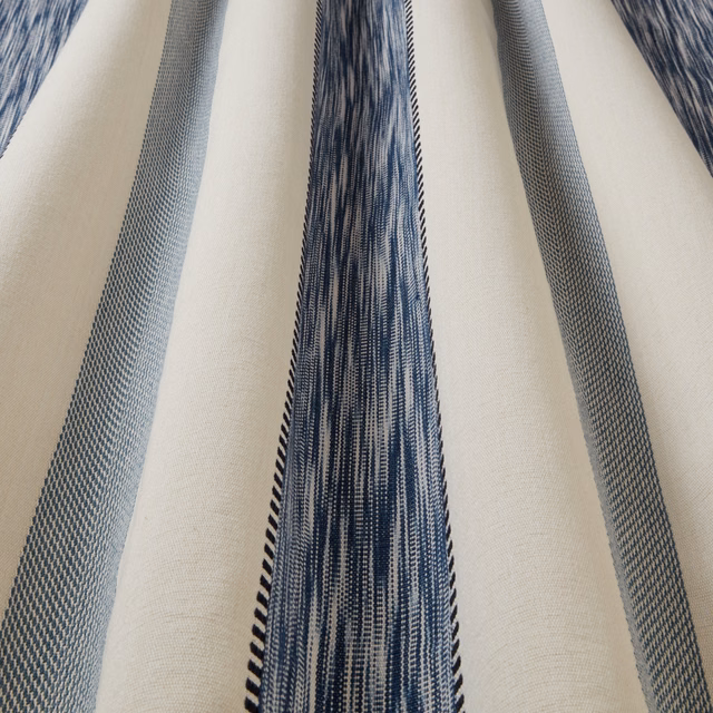 Close-up of a natural cotton fabric with wavy blue vertical stripes