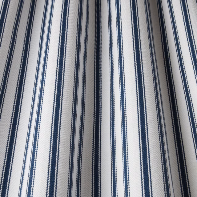 Ivory cotton fabric with narrow navy vertical stripes and subtle herringbone weave