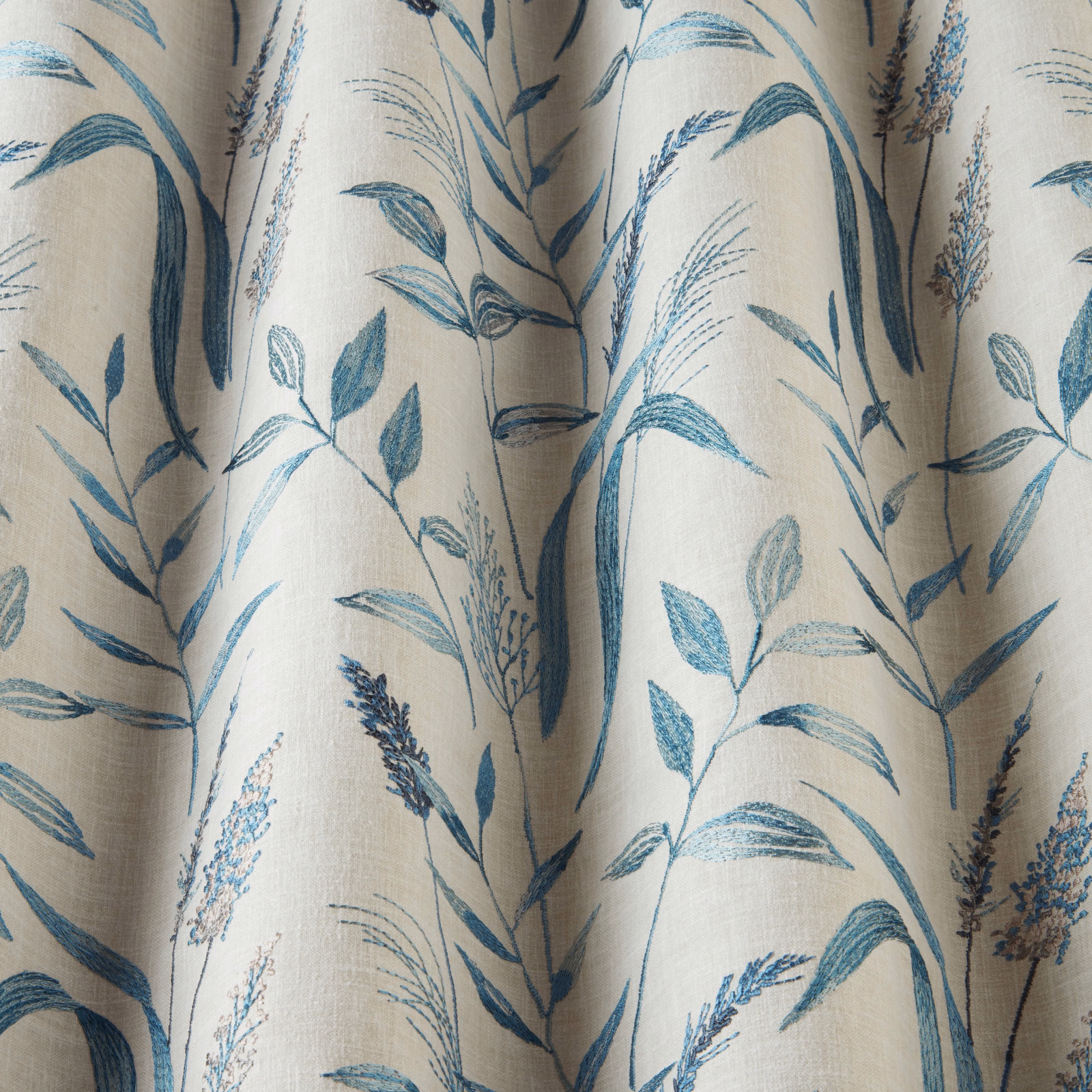 Cream cotton fabric with cobalt blue meadow stems and leafy botanical print