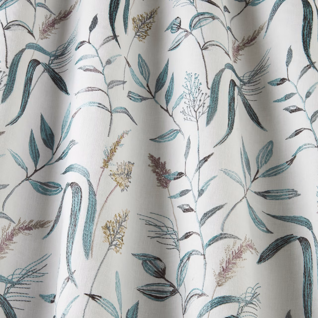 Light cotton fabric with teal and blue botanical stems on a pale ground