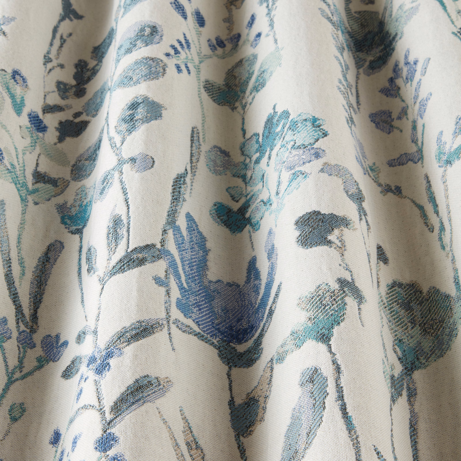 Cobalt and teal botanical cotton fabric with painterly leaf trail on ivory ground