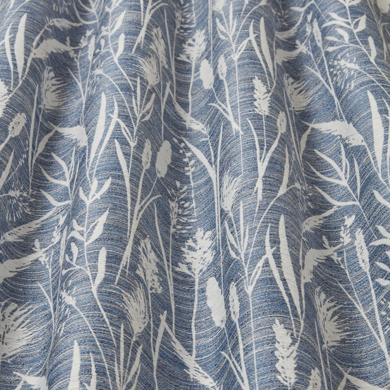 Cobalt blue fabric with white wavy grasses and reeds in a botanical print