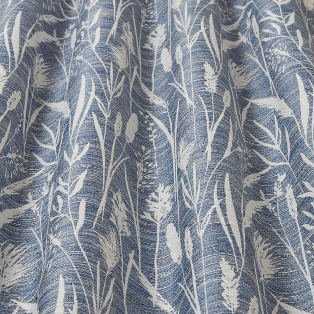 Cobalt blue fabric with white wavy grasses and reeds in a botanical print