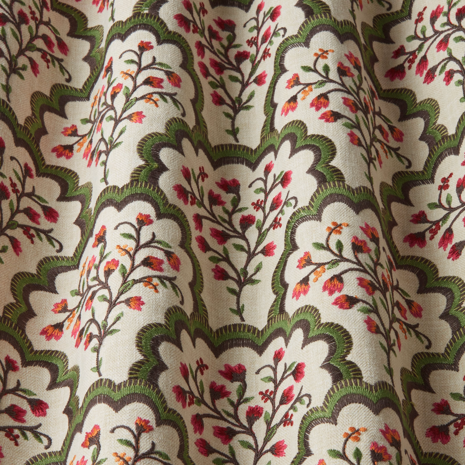 Cream fabric swatch with green scalloped arches and pink floral embroidery