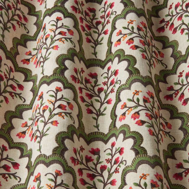 Cream fabric swatch with green scalloped arches and pink floral embroidery