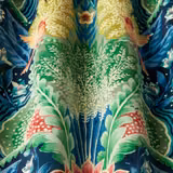 Close-up of a bold botanical fabric with midnight blue ground and vivid green leaves