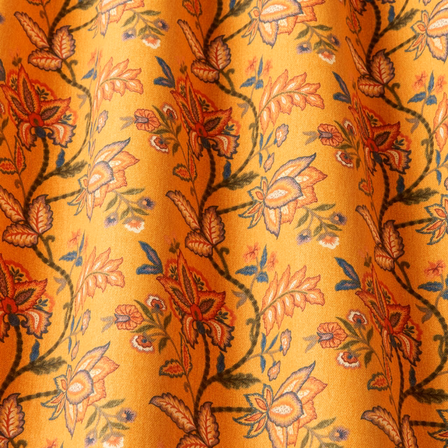 Golden cotton fabric with winding floral vines in red, green and blue