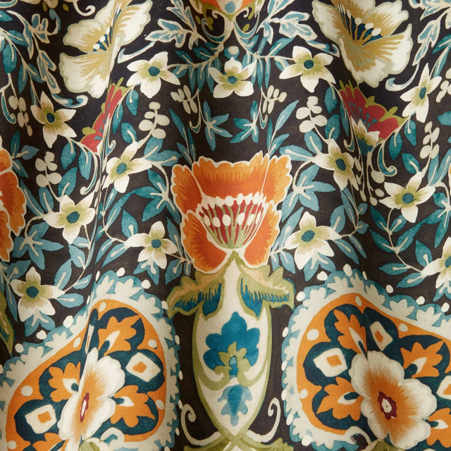 Bold botanical cotton fabric on an inky black ground with teal, cream and orange flowers