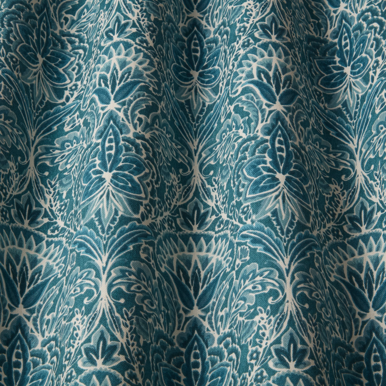 Teal cotton damask fabric with cream outlined floral pattern and soft folds