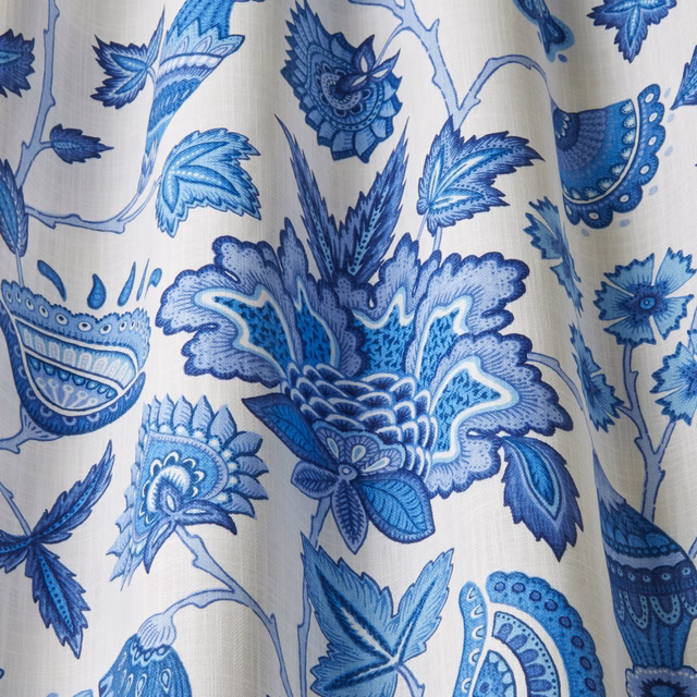 Blue batik floral cotton fabric with large leafy motifs on a cream ground
