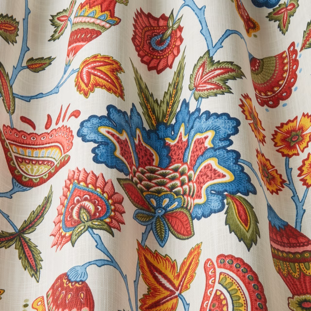 Cream cotton fabric with large wavy floral tapestry motifs in blue, red and green