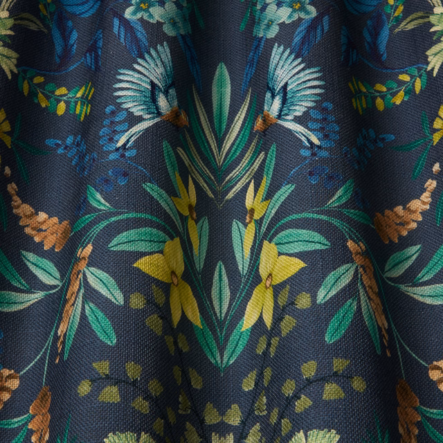 Deep navy botanical fabric with large green, teal and yellow floral leaves