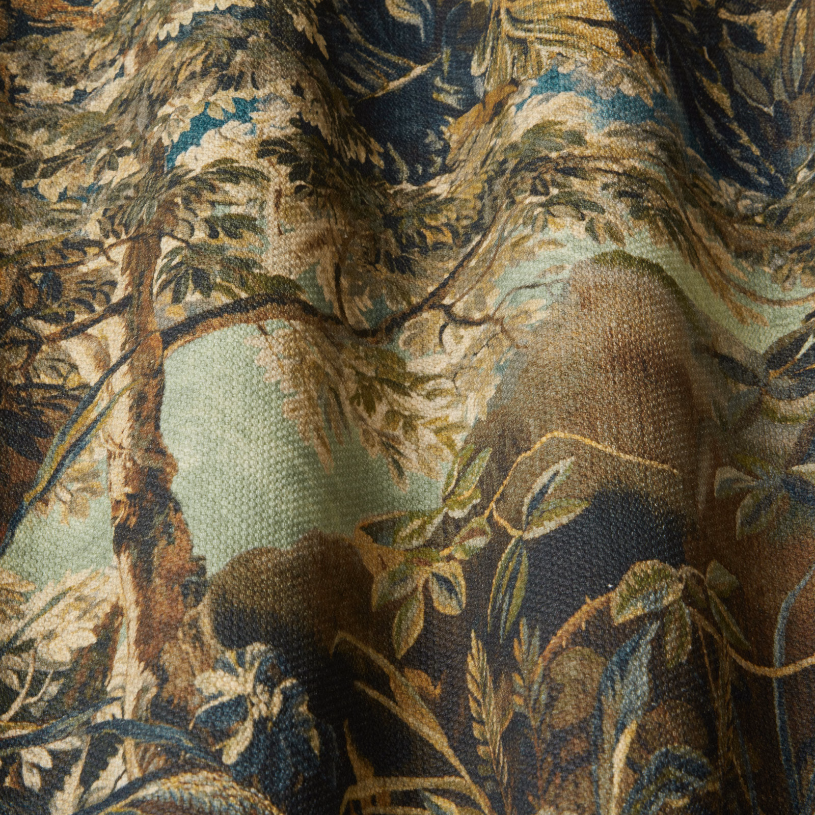 Forest-toned botanical fabric with moss green ground and dark leafy branches