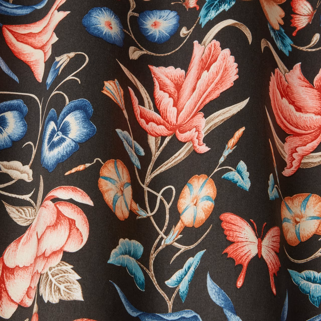Dark botanical fabric with coral flowers, blue butterflies and a black ground
