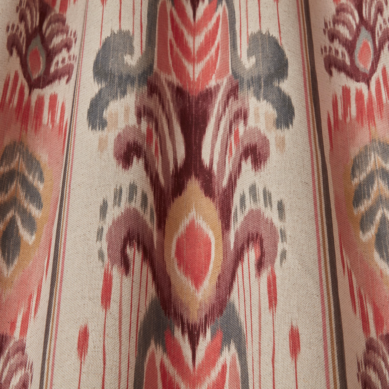 Cream fabric swatch with large ikat-style pink, berry and grey motif