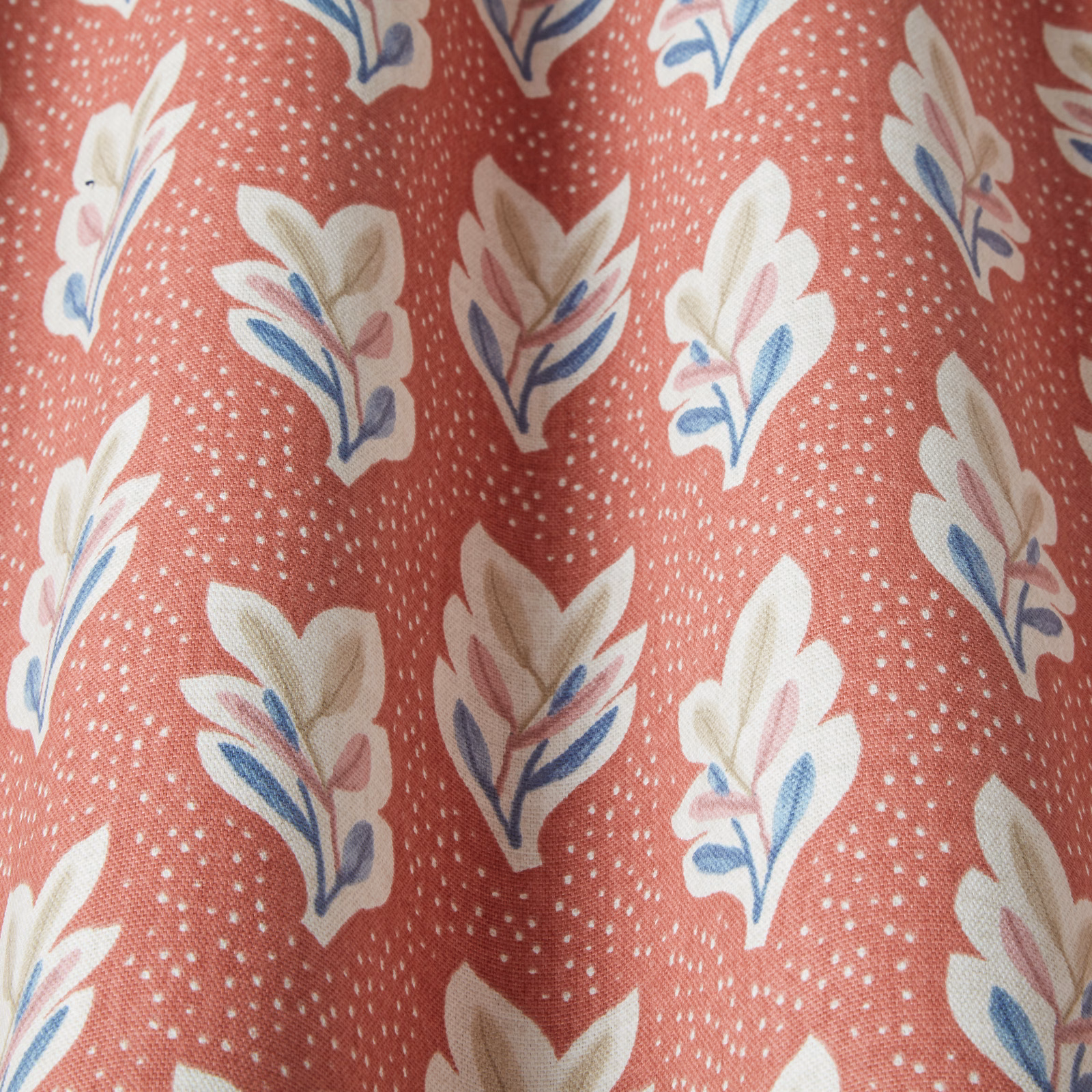 Coral terracotta fabric with white speckle and cream leaf motif with blue accents
