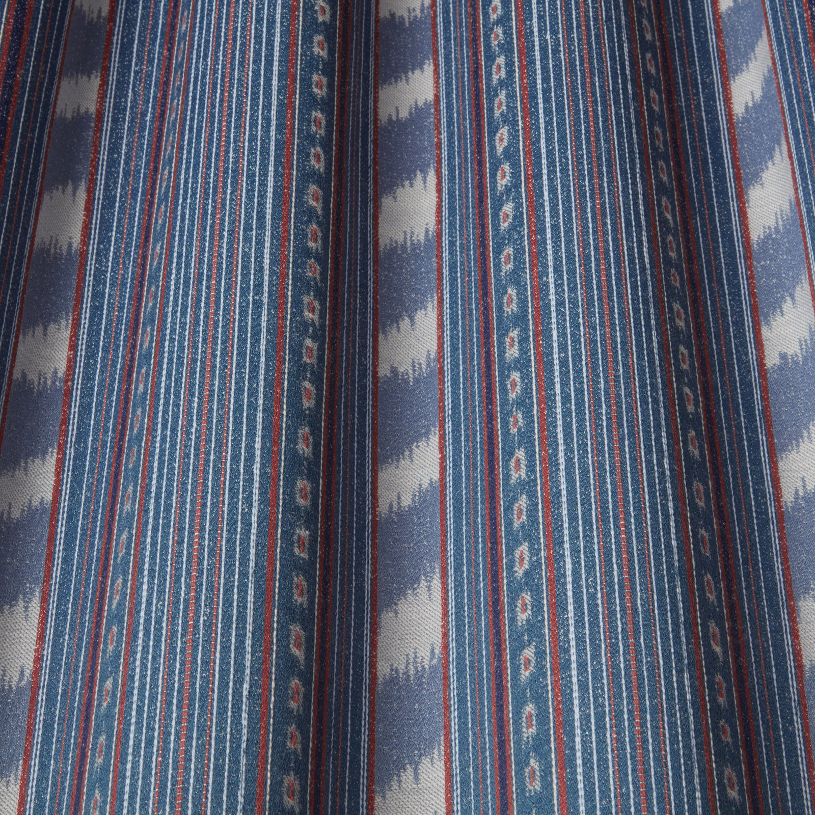 Indigo striped fabric with batik-style pale wave bands and fine red accents