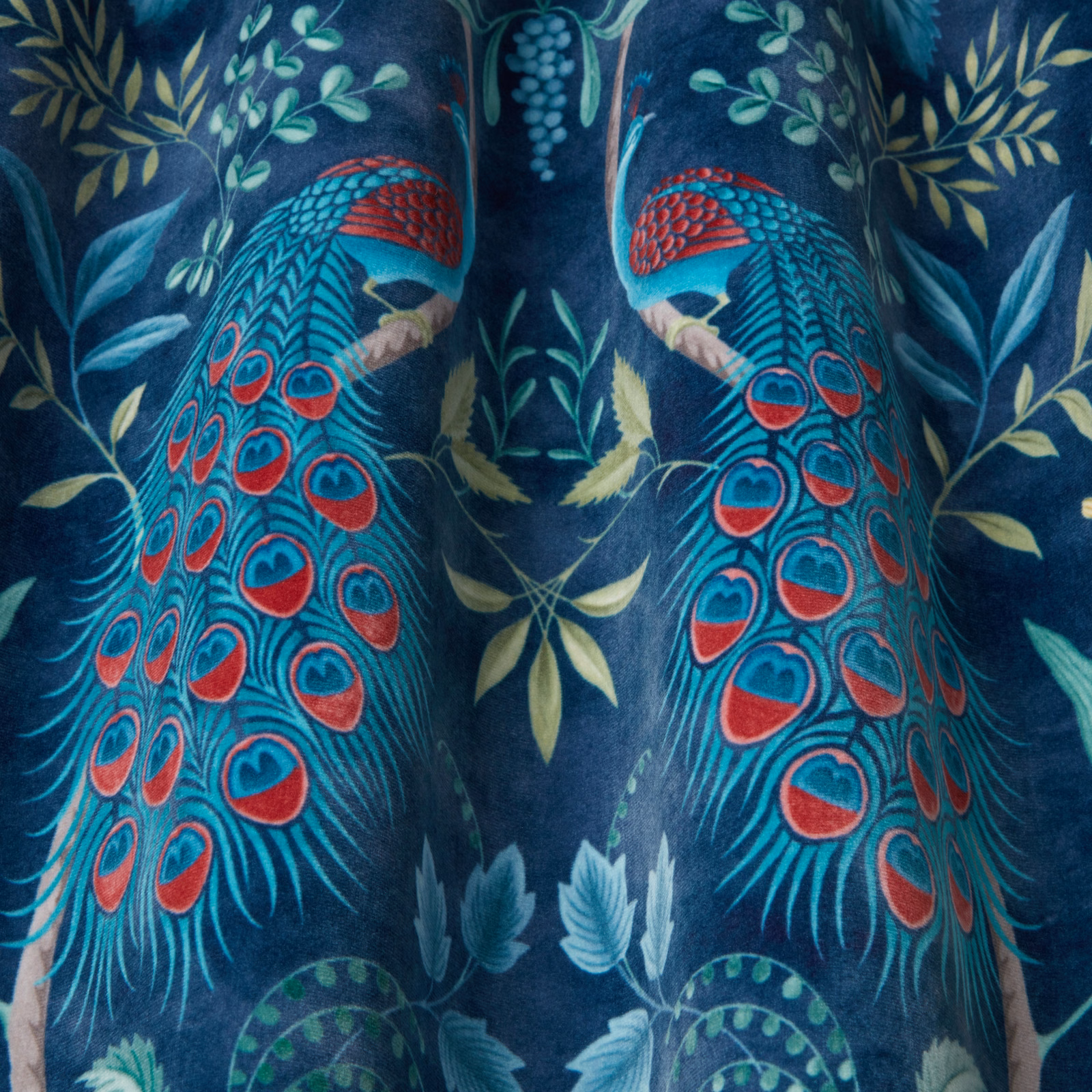 Deep navy fabric with large peacock motifs in teal, red and turquoise
