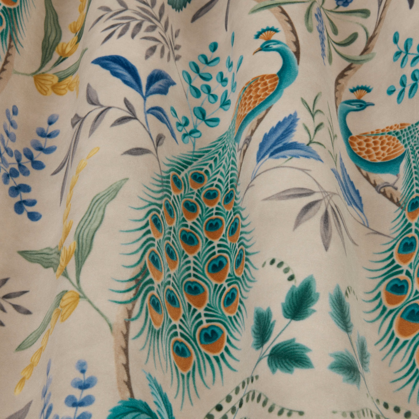 Teal peacock and foliage print on a warm ivory viscose-linen fabric swatch
