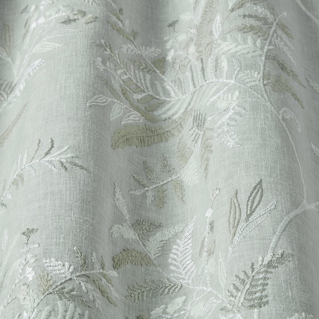 Pale sage-green botanical fabric with woven leaf motif and soft sheen