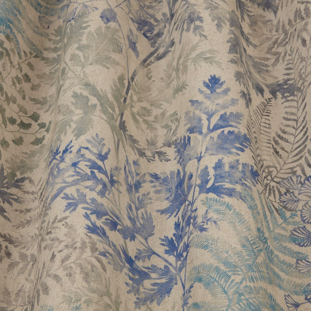 Painted botanical fabric with delft blue and sage foliage on a pale ground