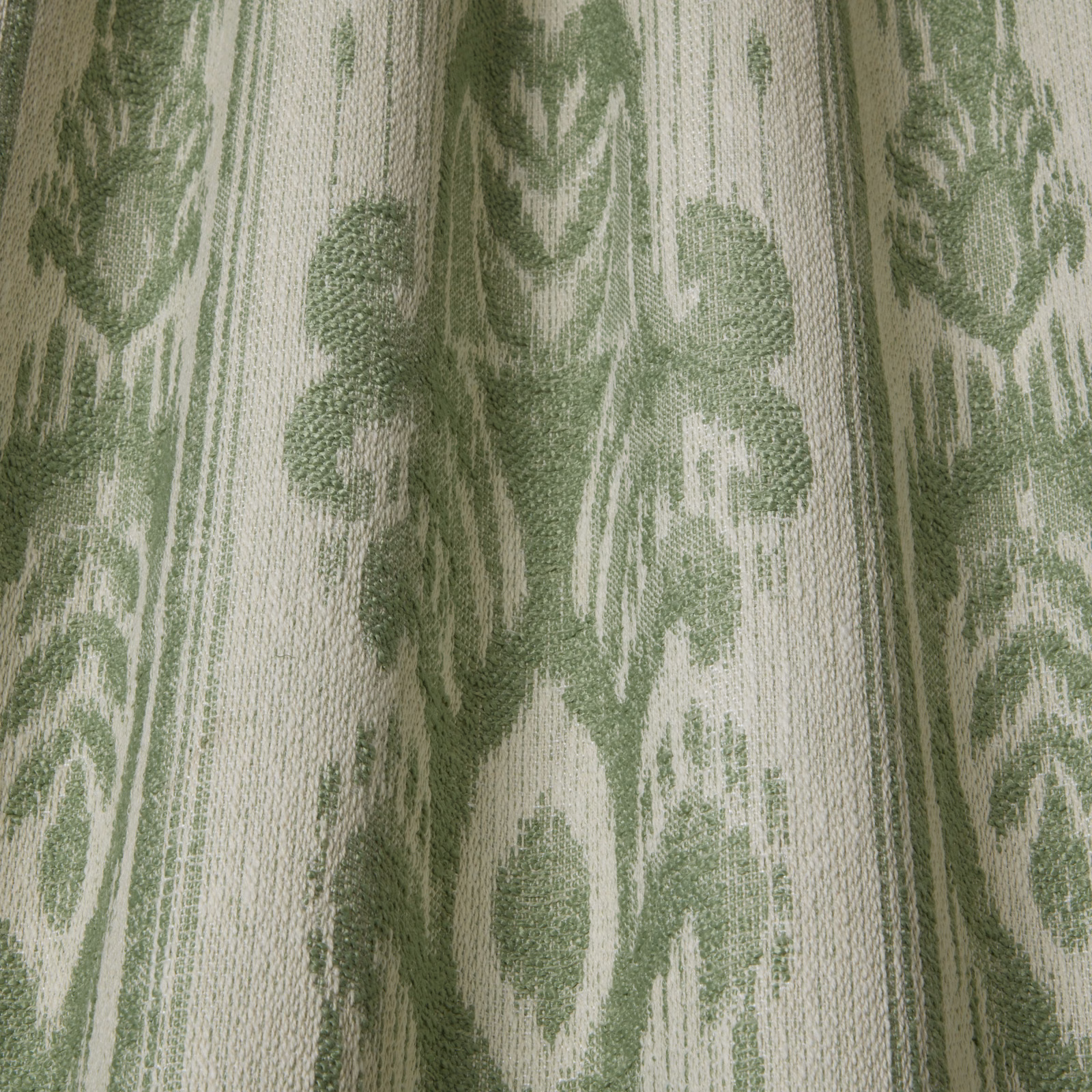Close-up of sage green and ivory woven botanical fabric with a large repeating leaf motif
