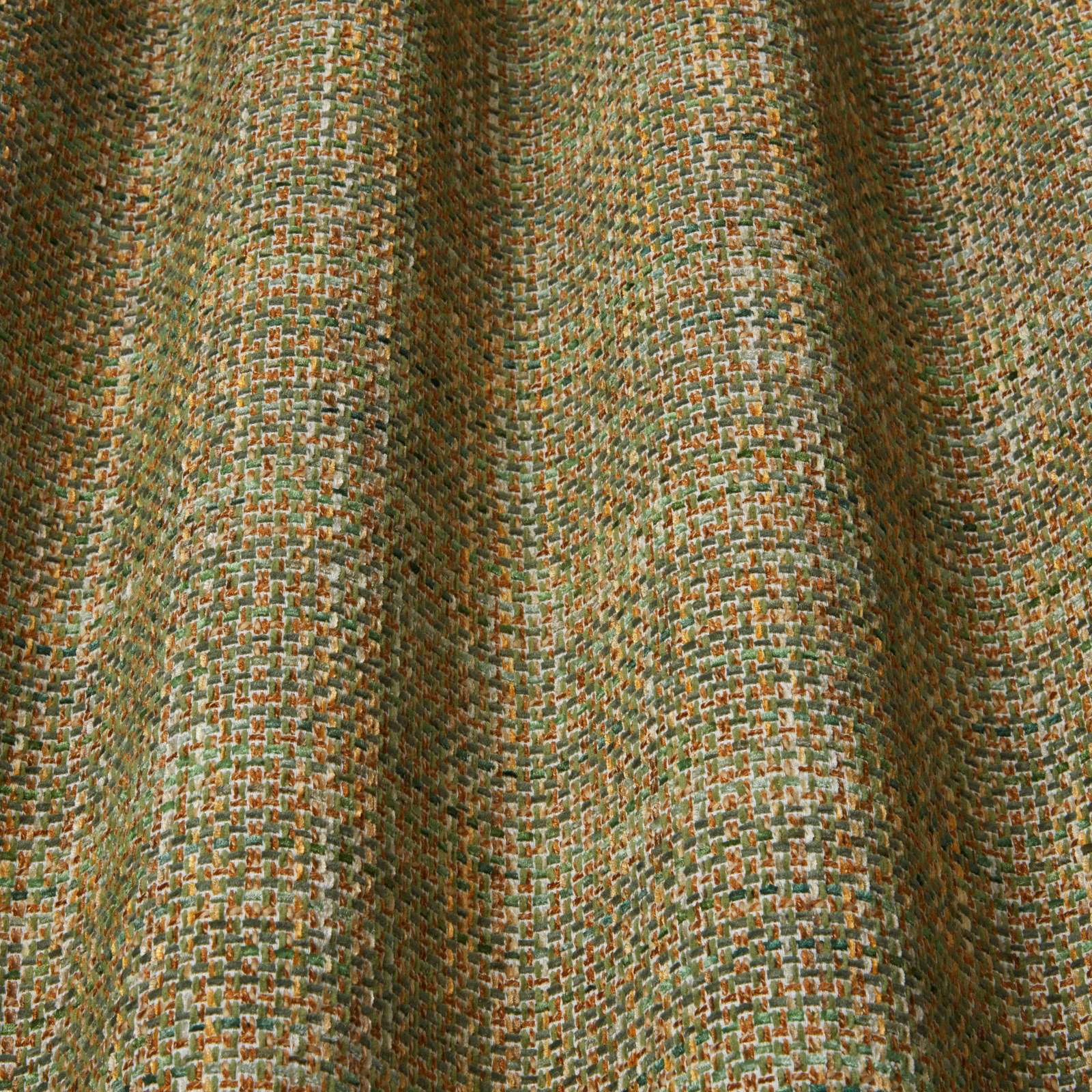 Close-up of green and amber textured woven fabric with small wavy pattern