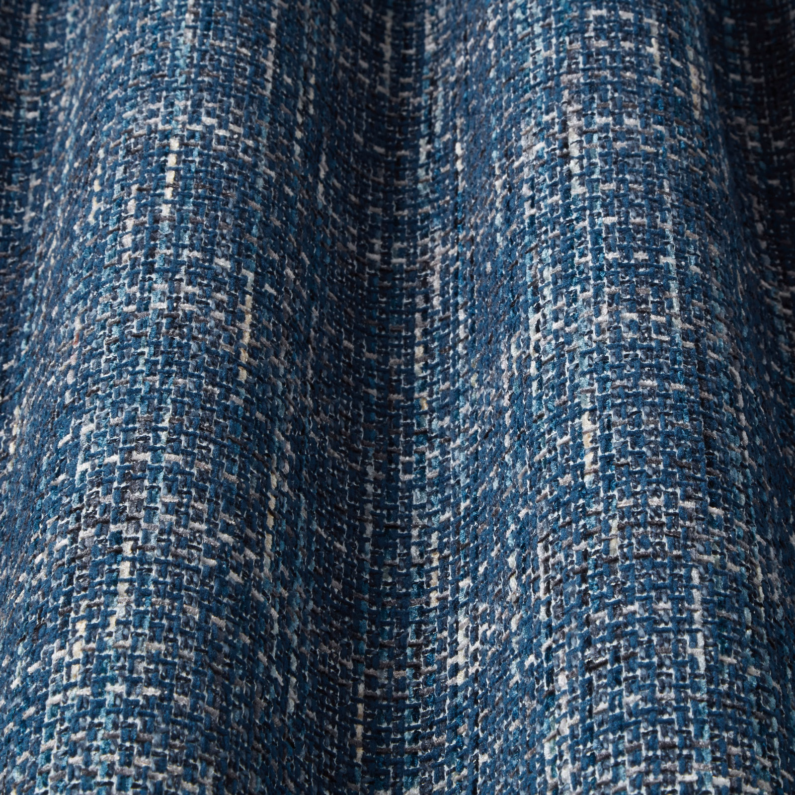 Blue and teal batik-style woven fabric with a wavy vertical pattern