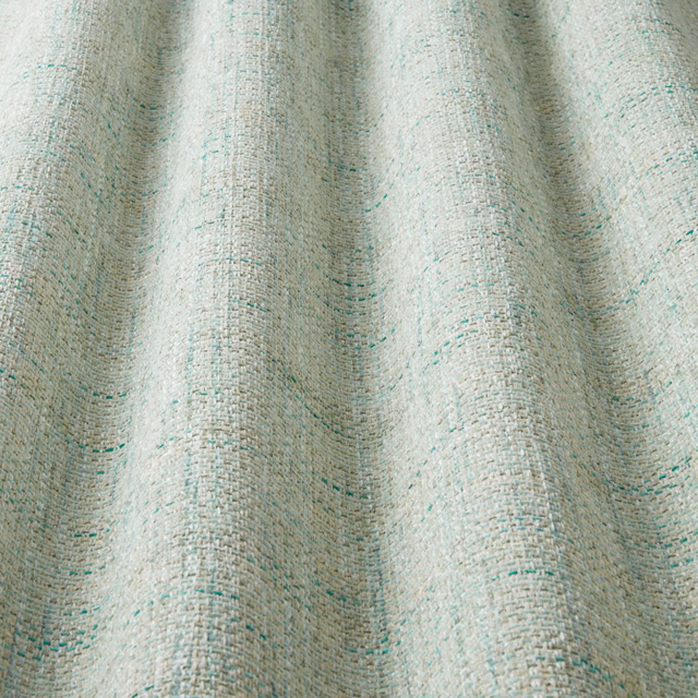 Pale eucalyptus green woven fabric with wide wavy pattern and fine speckled texture
