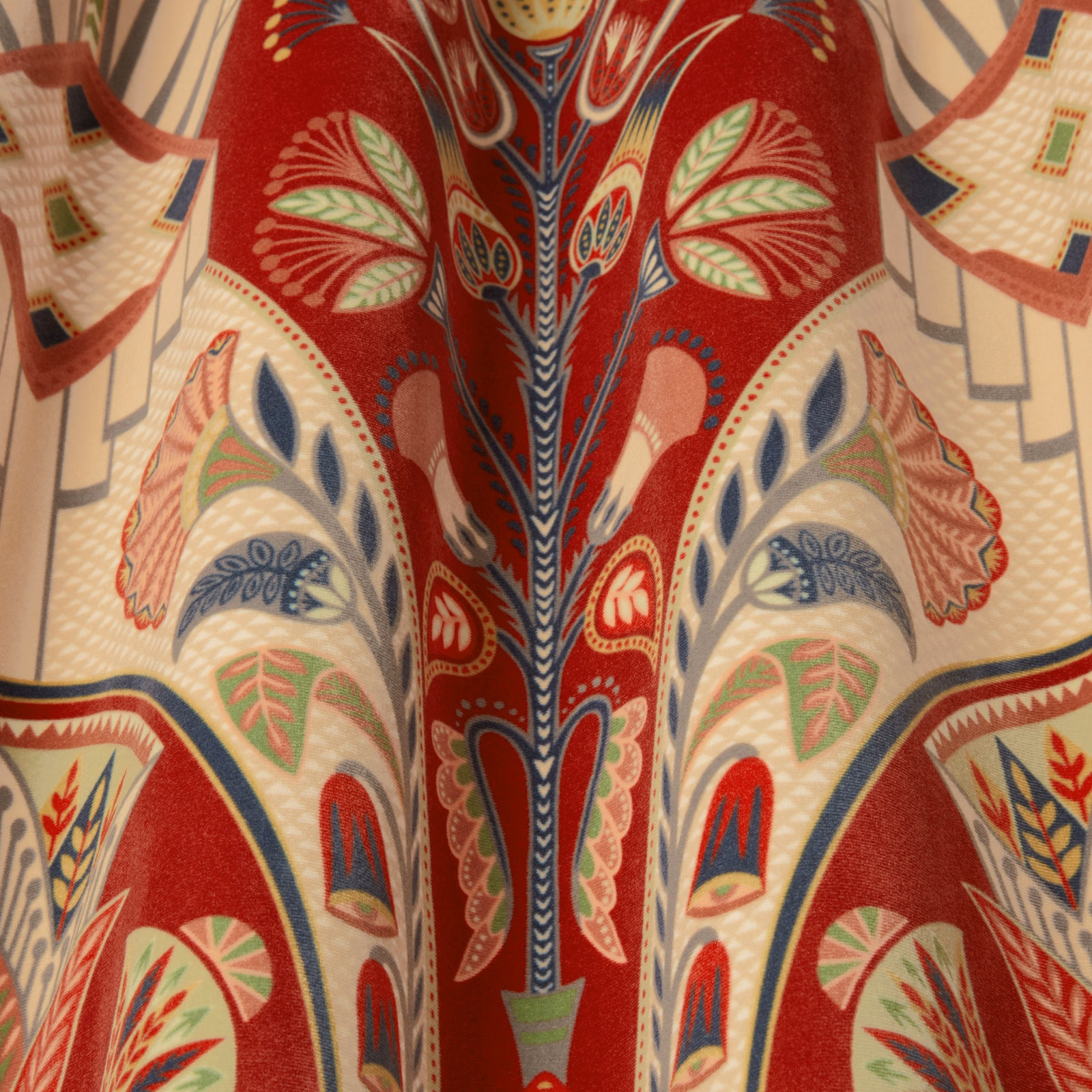 Close-up of garnet red patterned fabric with cream, navy and green motifs