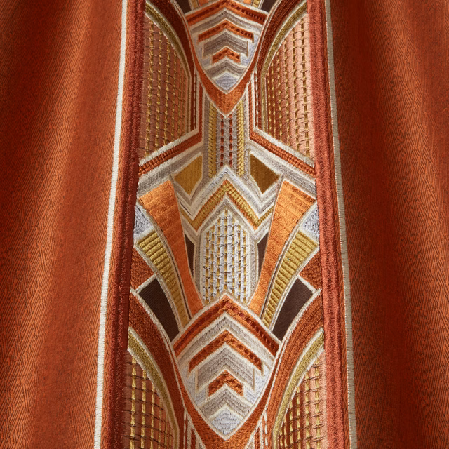 Geometric amber and rust woven fabric with cream accents and a textured red ground