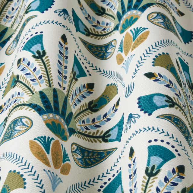 Emerald teal botanical patterned fabric with blue and gold leaf motifs on ivory