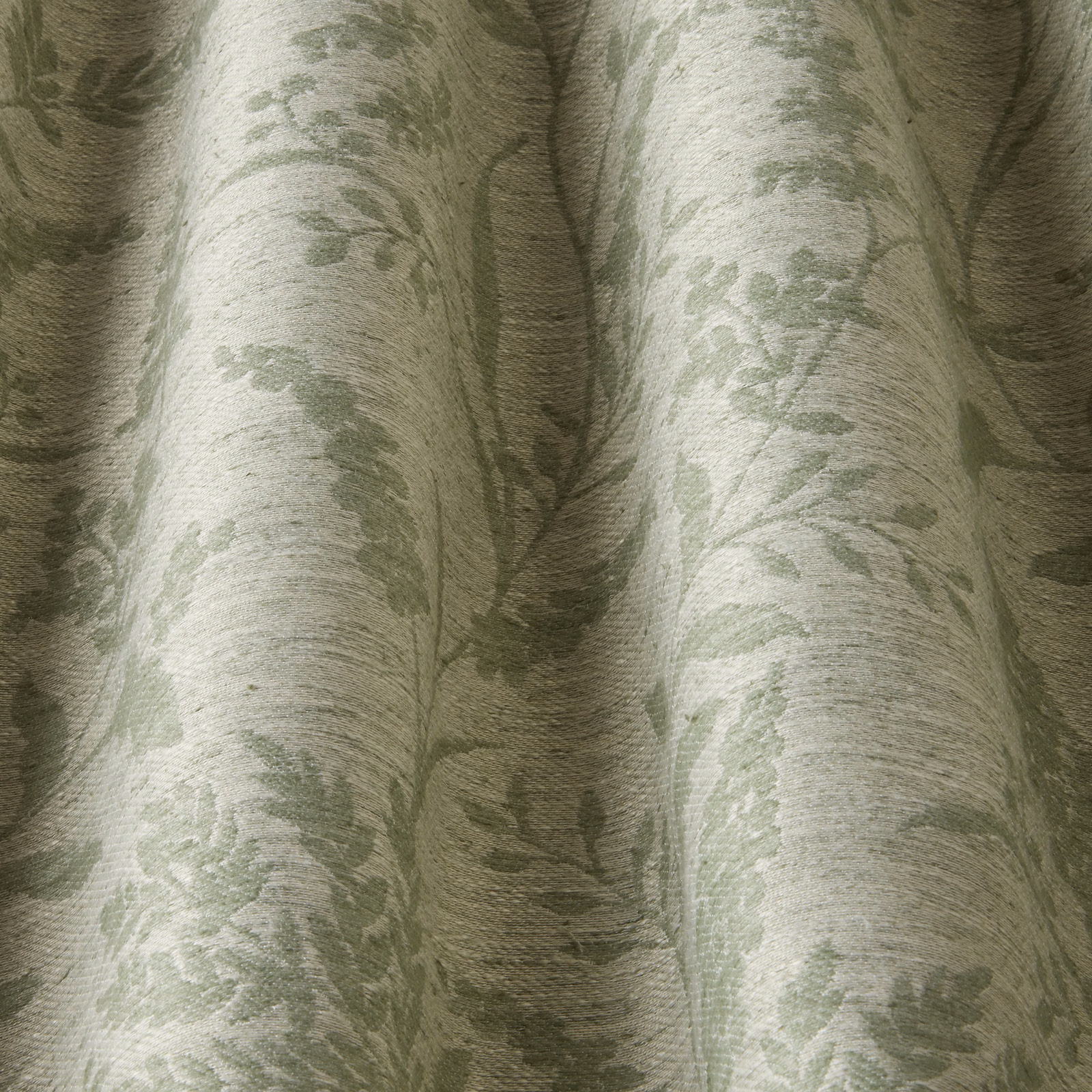 Soft sage green floral jacquard fabric with a wavy woven texture and gathered folds