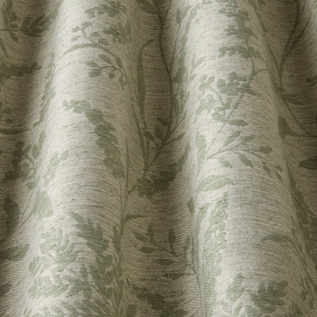 Soft sage green floral jacquard fabric with a wavy woven texture and gathered folds