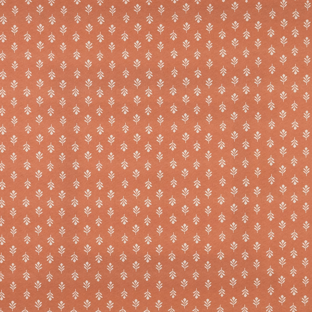 Terracotta cotton fabric with tiny cream leaf sprigs in a small repeating chintz pattern