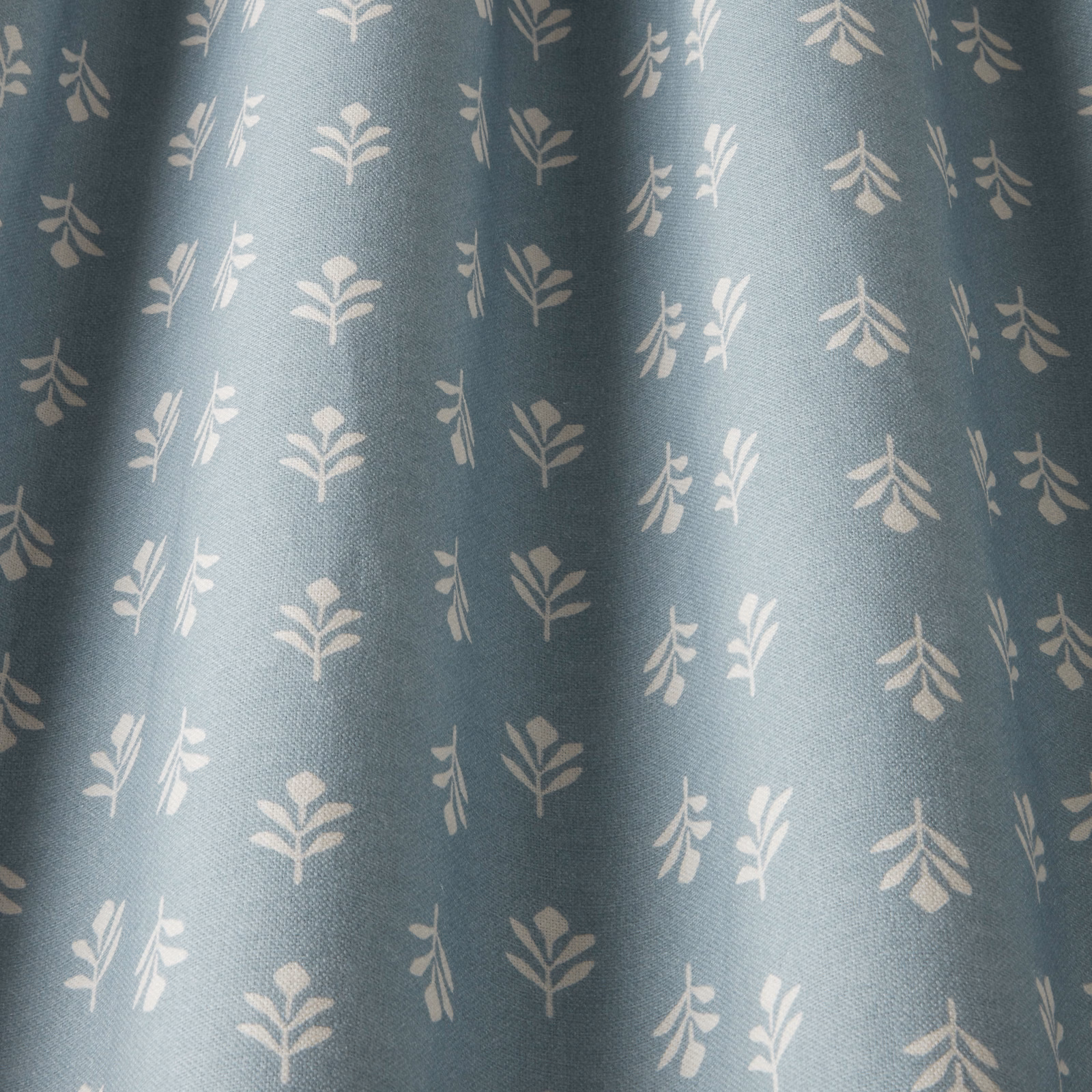Soft sky blue cotton fabric with small pale botanical sprigs
