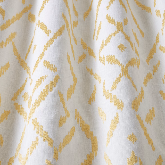 White cotton fabric with warm barley-gold wavy geometric pattern