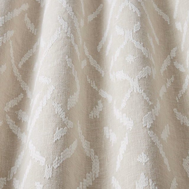 Cream cotton fabric with a raised wavy white pattern and soft texture