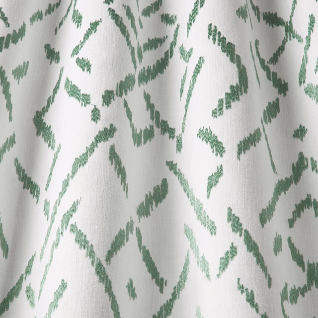 Off-white cotton fabric with sage green wavy abstract marks