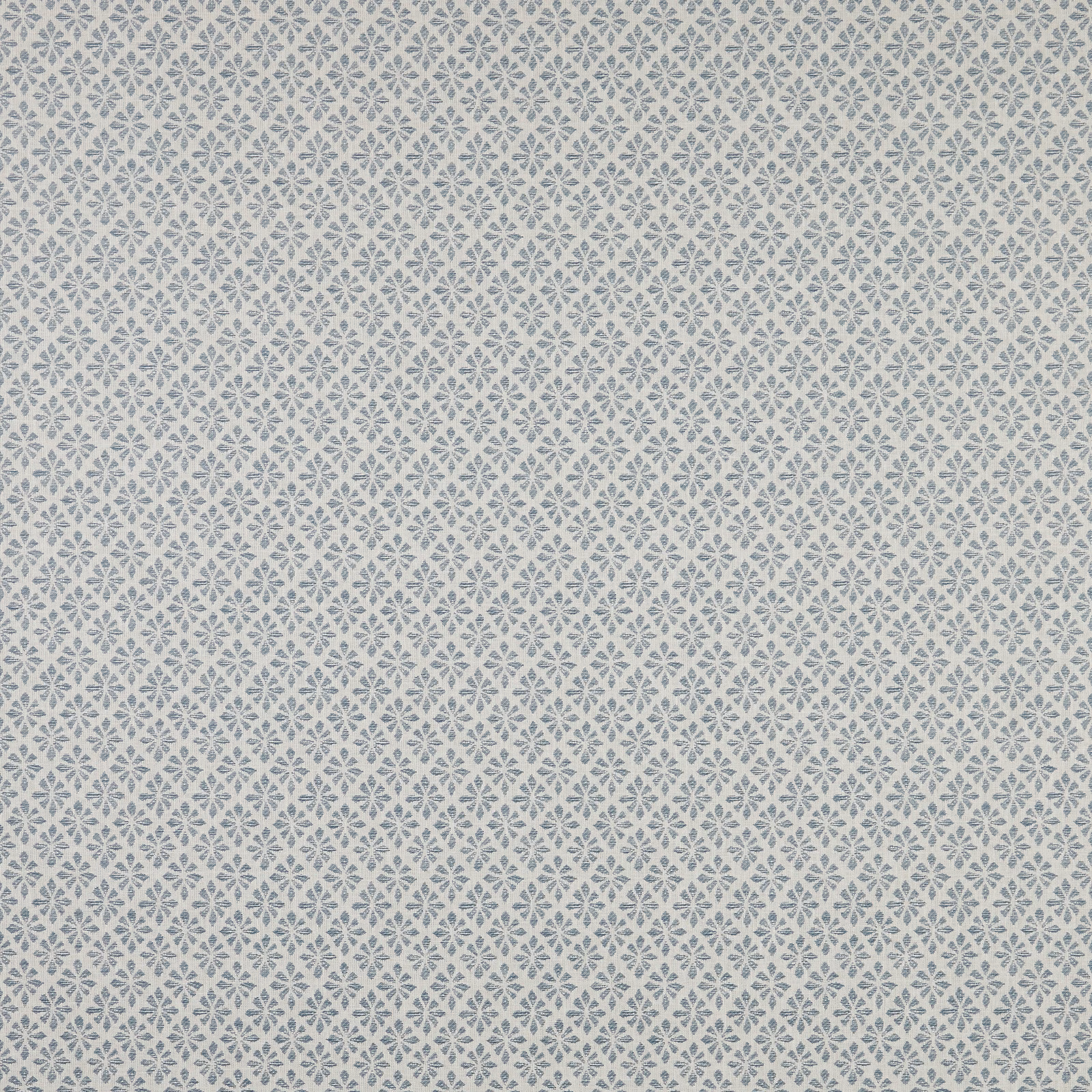 Close-up of pale cotton fabric with tiny denim-blue geometric floral diamonds