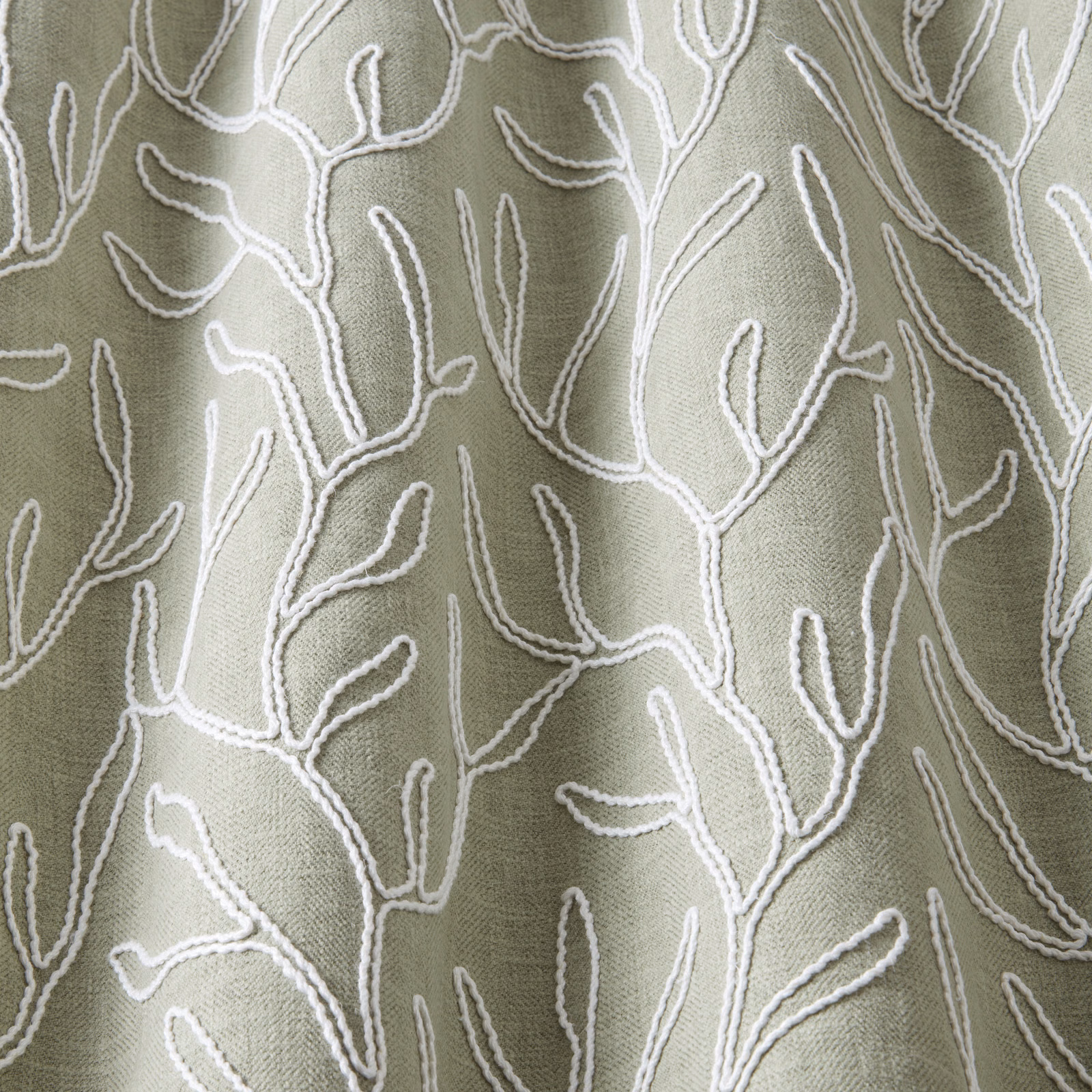Soft sage green cotton fabric with raised ivory wavy botanical embroidery