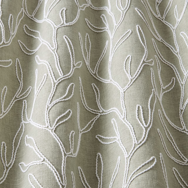 Soft sage green cotton fabric with raised ivory wavy botanical embroidery