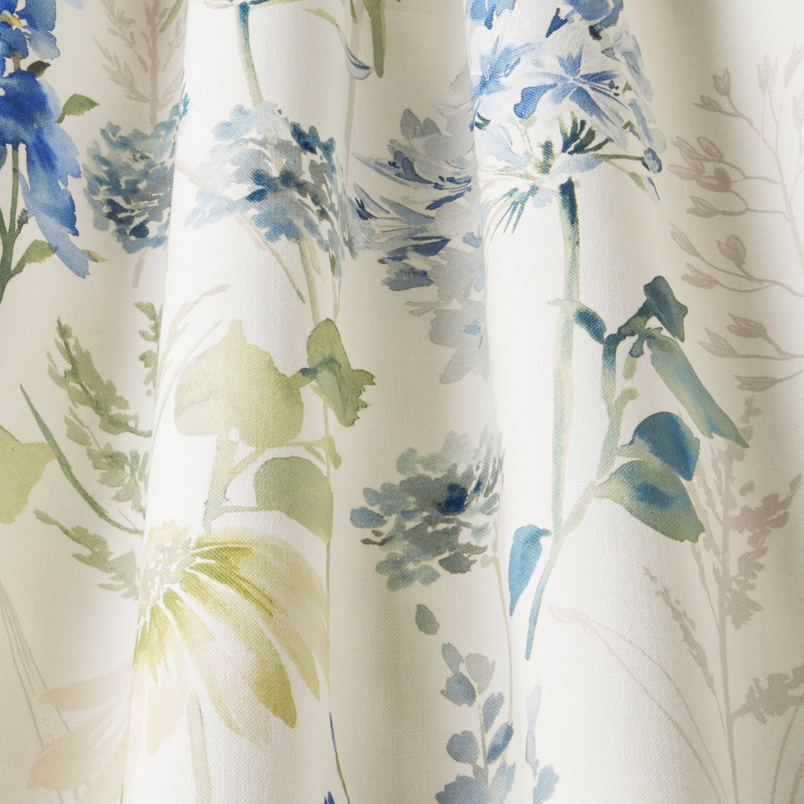 Painterly cornflower blue and sage floral fabric on a cream ground