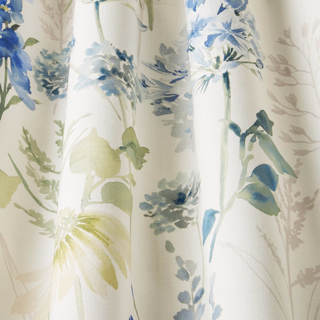 Painterly cornflower blue and sage floral fabric on a cream ground
