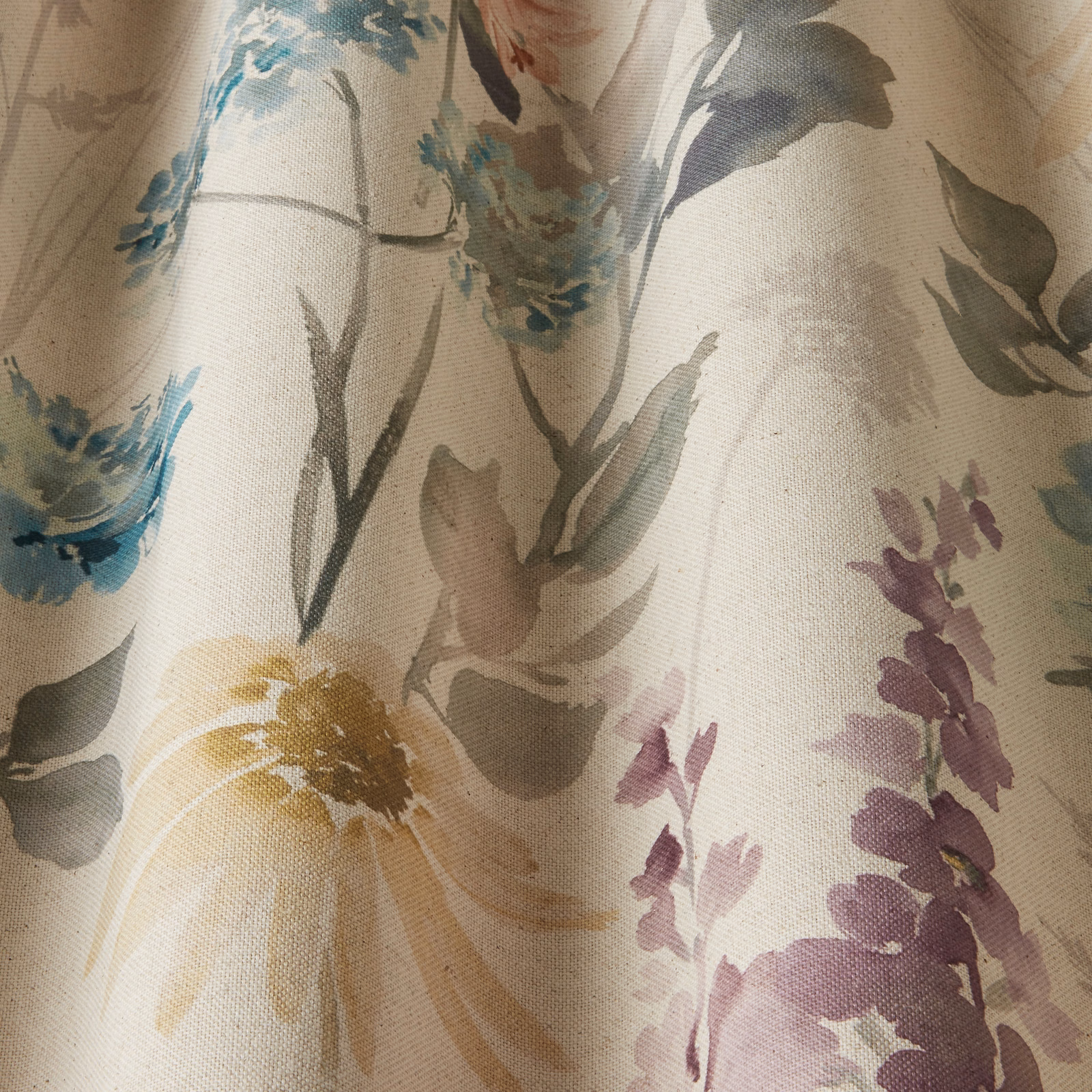 Painterly floral cotton fabric in sky blue, lilac, sage and ochre on a pale linen ground
