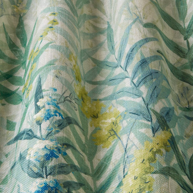 Close-up of painterly green and aqua wildflower print on woven cotton