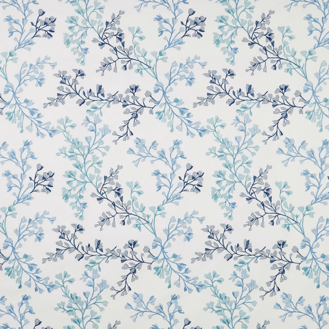 Cream cotton fabric with trailing leaf branches in cornflower, teal and navy